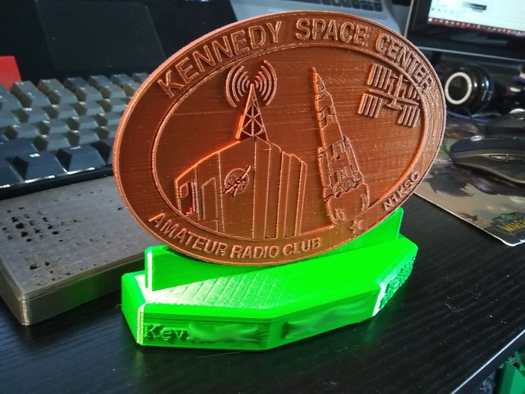 A finished copper logo on a green test plaque base